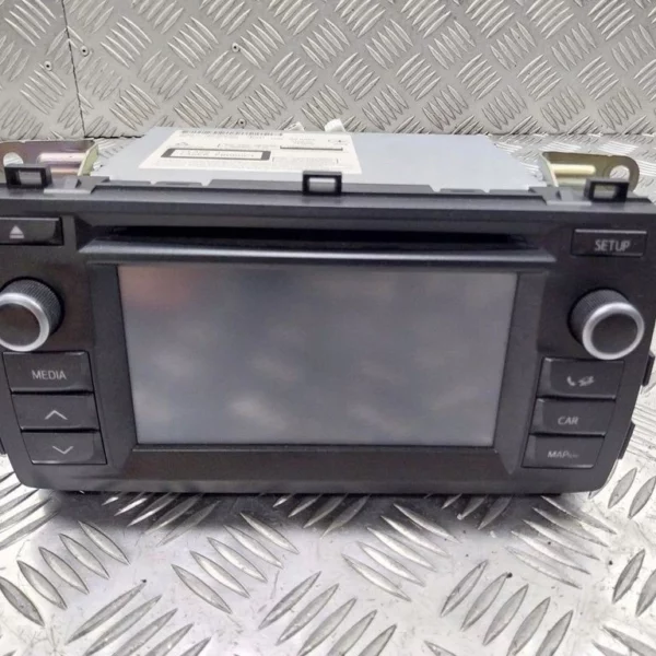 Car stereo head unit with a central touchscreen and labeled media, setup, and car/map controls on a metal diamond plate surface